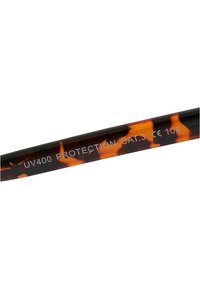 Monture de lunettes de soleil au motif écaille de tortue avec une finition brillante. Le texte sur la branche indique "PROTECTION UV400 CAT.3 CE 106."