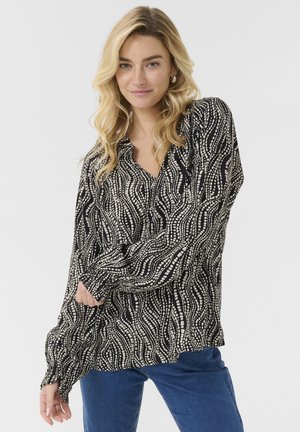 Black and cream blouse featuring a wavy pattern, made from lightweight fabric, with long sleeves and a V-neckline.