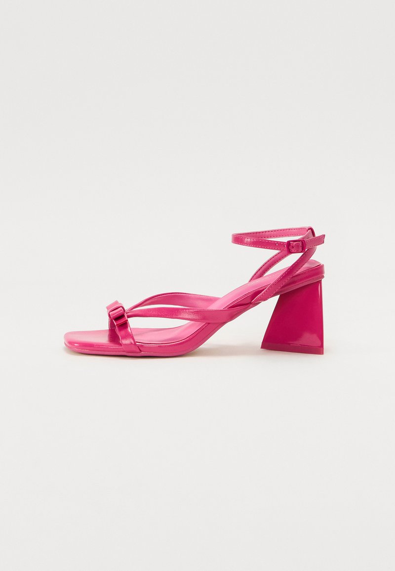 Rosa patentlær heeled sandaler med firkantet tå, smale stropper og en geometrisk blokklitt. Har en spenne detalj på stroppen.