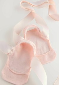 Scarpette da balletto rosa realizzate in tessuto morbido con nastri di raso. Le scarpe hanno una texture liscia e una forma arrotondata, progettate per il comfort.