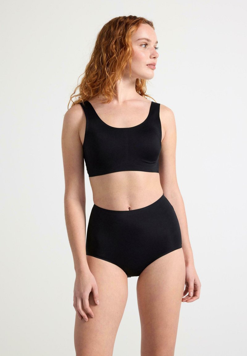 Mustat bralette, jossa on leveät hihnat, sekä korkeavyötäröiset mustat alushousut, jotka on valmistettu sileästä kankaasta, saumattomalla muotoilulla ja minimalistisella tyylillä.