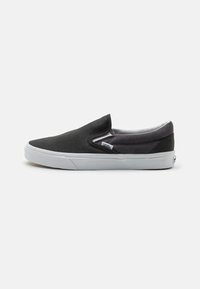Černé plátěné slip-on boty s gumovou podrážkou, které mají nízkoprofilový design a elastické boční detaily pro snadné obouvání.