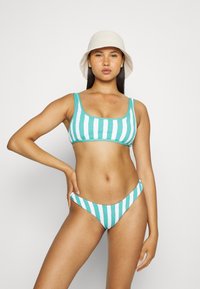 Conjunto de bikini listrado em turquesa e branco com um acabamento texturizado. O topo apresenta um decote quadrado e alças largas; a parte de baixo tem uma cintura baixa.