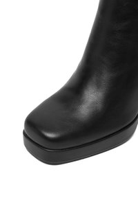 Czarne skórzane botki za kostkę z kwadratowym noskiem, gładką fakturą i masywnym obcasem, charakteryzujące się minimalistycznym wzornictwem i brakiem widocznych zdobień.