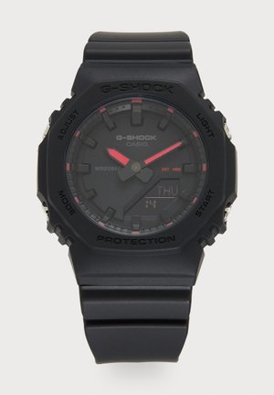 G-SHOCK horloge met een matte zwarte hars band en kast, met een digitale en analoge weergave met rode accenten. Waterdicht tot 20 bar.