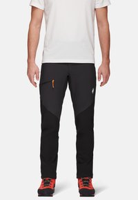 Zwarte buitenbroeken met contrasterende matte en textuurstof, voorzien van een oranje ritszak, een tapered fit en logo-details op het been.