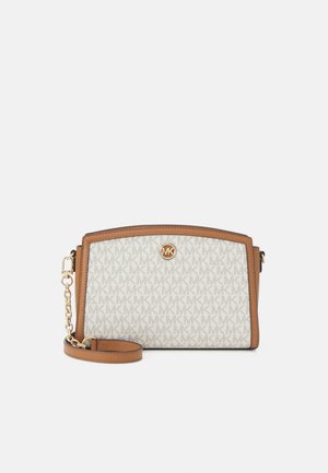 Michael Kors polspetje portemonnee met tan leren rand, gouden kettingriem en crème stof met logopatroon.
