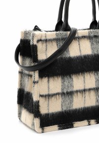 Sac à main en laine à motif à carreaux noir et beige, avec deux poignées en cuir noir et une bandoulière amovible.