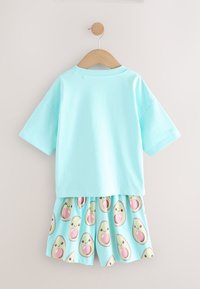 Mintroheline lühikeste varrukatega särk sobitatud sobiva seelikuga, millel on naeratavate avokaadode muster helel sinisel taustal.