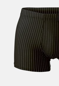 Zwarte boxershorts met dunne witte verticale strepen, elastische tailleband en een zachte stofstructuur, met een aansluitende snit.