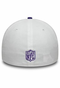 Gorra blanca con un logo de la NFL en púrpura en la parte posterior, con una visera plana y una textura de tela suave. Pequeño acento púrpura en la parte superior.