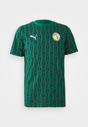 Green short-sleeve T-shirt made of textile with a geometric black pattern, featuring a Puma logo and a circular emblem on the chest.