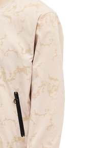Giacca beige chiaro con motivo marmorizzato in tonalità crema, dotata di una tasca con zip nera e tessuto liscio e testurizzato.