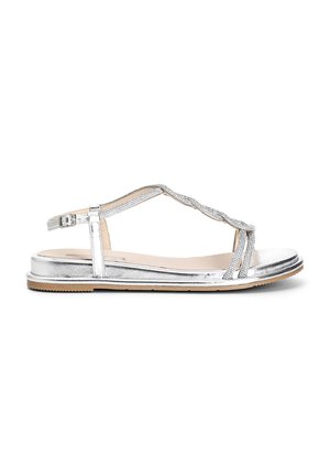 Stříbrné metalické sandály s designem T-strap, texturovaným svrškem a plochou podrážkou. Doplněné tkaným páskem a přezkou. Lehká konstrukce.