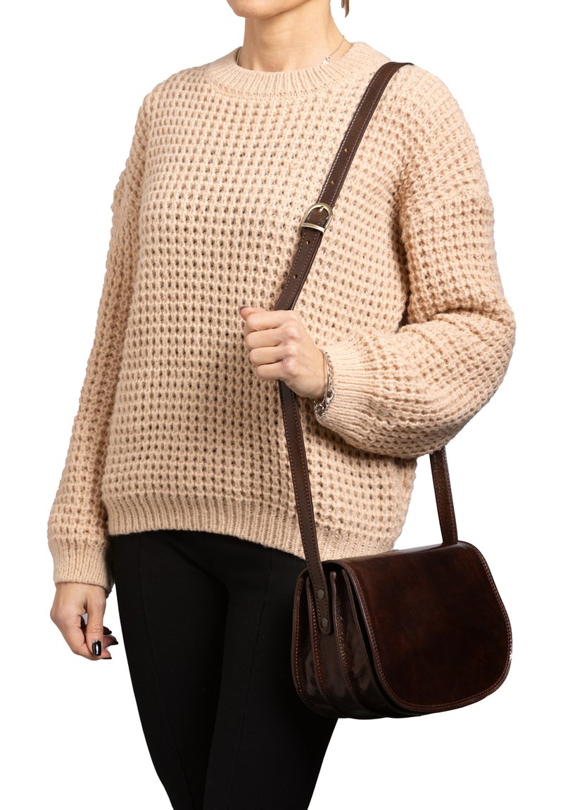 Borsa a tracolla in pelle marrone con una texture liscia e una pattina curva. Dotata di una sola tracolla regolabile attaccata con hardware in metallo.