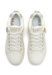 Baskets en cuir blanc avec des accents dorés, des panneaux texturés et des clous décoratifs. Comprend des lacets et un logo de marque en relief sur la languette.