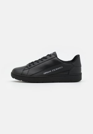 Baskets basses noires à lacets, finition lisse, avec "Armani Exchange" écrit sur le côté en lettres blanches.