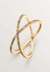 Anillo de oro con bandas entrelazadas, adornado con piedras preciosas multicolores en rosa, verde, azul y naranja a lo largo de los bordes. Textura suave.