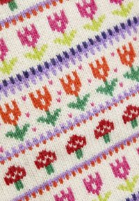 Stickad tyg med ett blommönster som har rosa, orange och röda blommor, åtskilda av lila och gröna detaljer på en krämfärgad bakgrund.