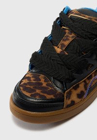 Viacfarebné tenisky s leopardím vzorom na vrchu, čiernymi koženými akcentmi, hrubými čiernymi šnúrkami a gumenou podrážkou.