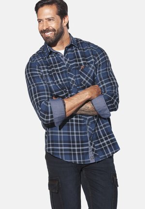 Blau kariertes Hemd mit langen Ärmeln, Jeansdetails und Knopfverschluss. Verfügt über eine Brusttasche mit einem bestickten Logo.