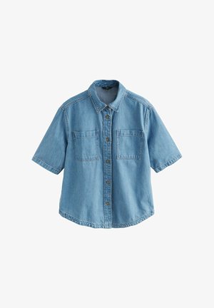 Világoskék, rövid ujjú farmering klasszikus gallérral, két elülső zsebbel és barna gombzárral. Lazább szabású, ívelt alsó szegéllyel rendelkezik.