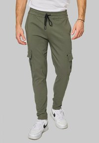 Pantalons cargo vert olive en tissu doux, avec des jambes fuselées, de multiples poches et une taille élastique avec un cordon de serrage.