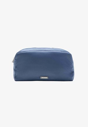 Trousse de toilette rectangulaire bleue avec fermeture éclair et petite étiquette métallique de la marque au centre avant sur fond blanc.