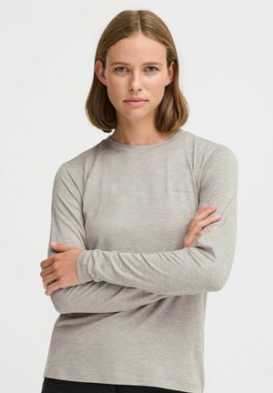 Lichtgrijs langwerpig shirt met lange mouwen, gemaakt van een zachte, gladde stof. Heeft een ronde halslijn en een subtiele logo-detail, met aansluitende mouwen.