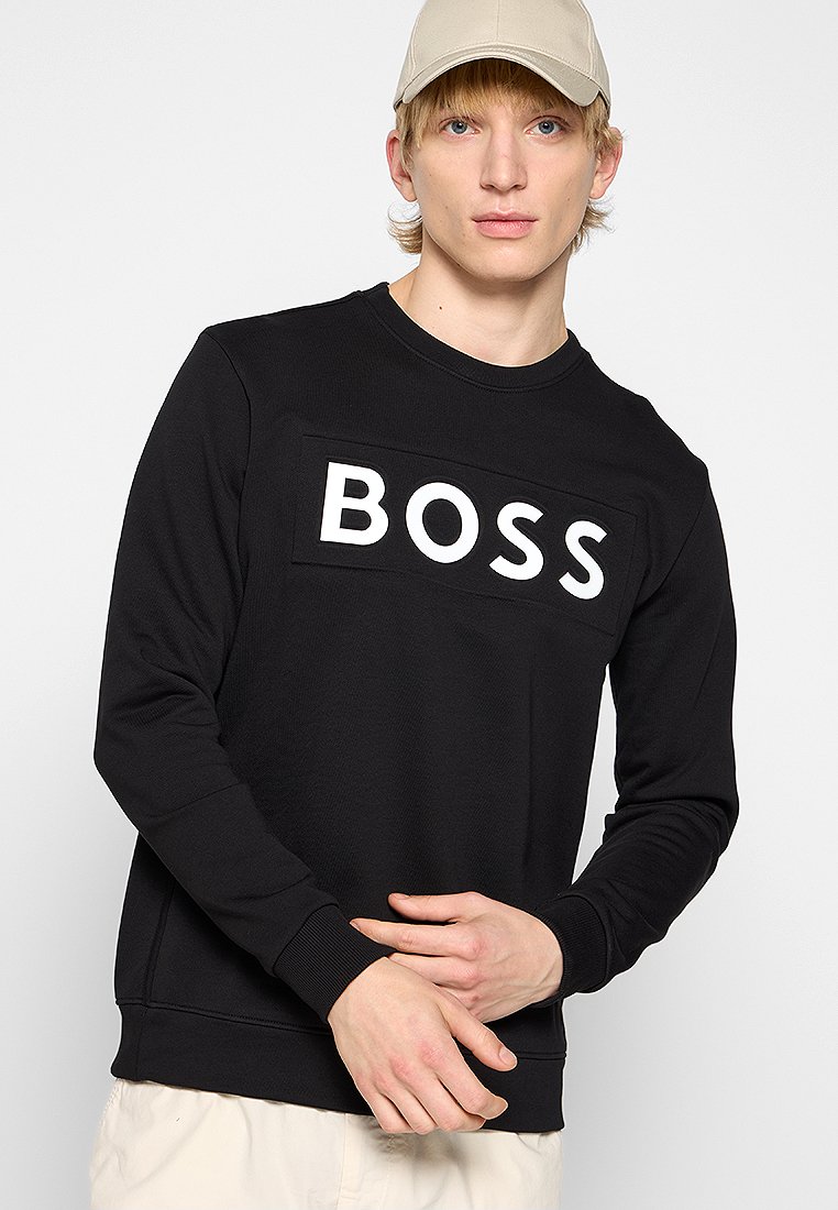Felpa nera realizzata in un tessuto testurizzato, caratterizzata da un logo rettangolare bianco "BOSS" sul davanti. Maniche lunghe con polsini a costine.