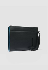 Zwarte leren clutch met een gladde textuur, voorzien van een bovenste rits, een polsriem aan de zijkant en een felblauwe binnenvoering.