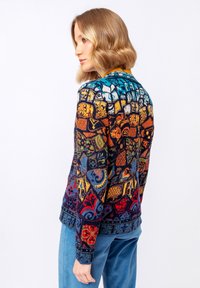 Svetr s mnoha barvami a vzory, s propracovanými designy v oranžové, modré a černé barvě, vyrobený ze strukturované pleteniny, s dlouhými rukávy.