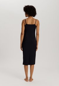 Vestido sin mangas de algodón negro con tirantes finos, de longitud a la rodilla, textura suave, diseño ajustado y estilo minimalista.