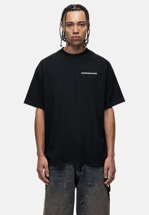 Black cotton t-shirt with a loose fit, round neckline, and short sleeves. Features white "GOODFOR NOTHING" text on the chest.