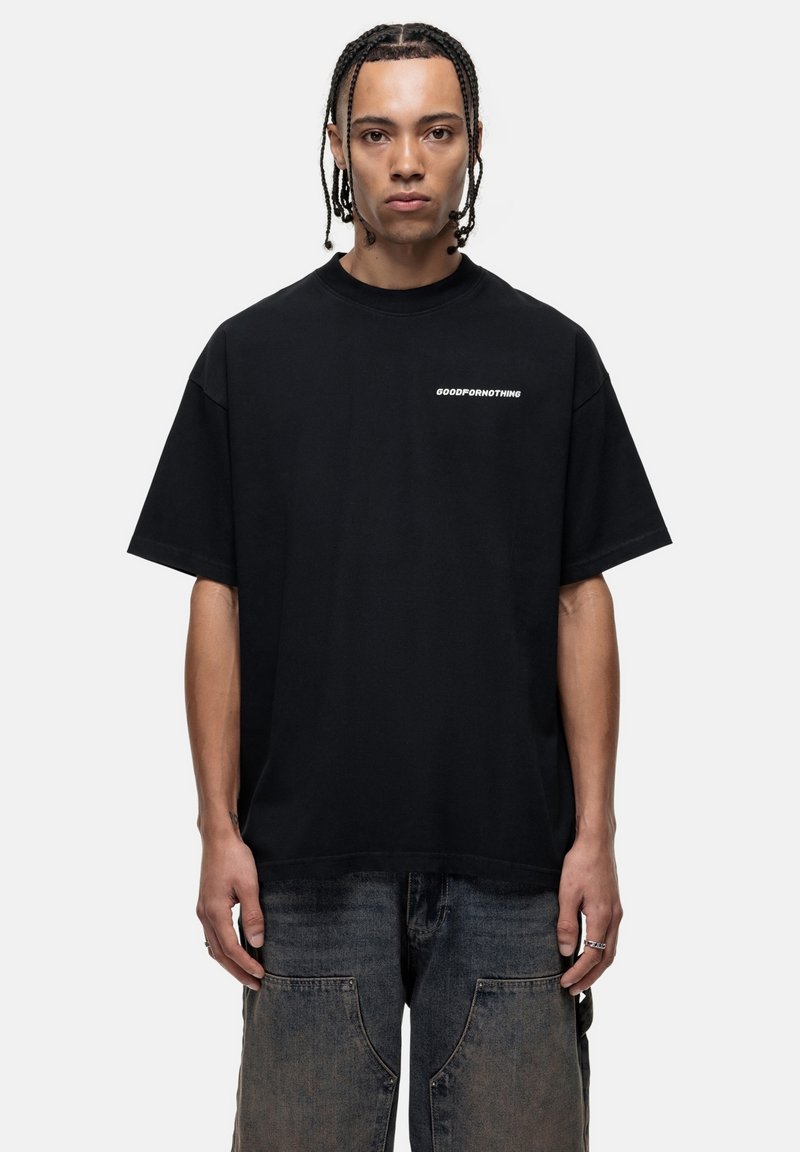 Zwarte katoen T-shirt met een losse pasvorm, ronde halslijn en korte mouwen. Bevat witte tekst "GOODFOR NOTHING" op de borst.