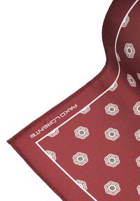 Czerwony jedwabny szalik z geometrycznymi wzorami w kolorze kremowym i zielonym, z białą krawędzią i logo "Paco Llorente" z jednej strony.