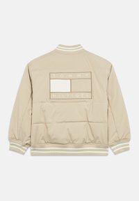 Giacca bomber imbottita beige con polsini e colletto a coste. Presenta una patta rettangolare con il logo sulla schiena con la scritta "TOMMY HILFIGER" in rilievo.