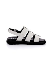 Sandalias de piel blanca con suela negra, que cuentan con correas anchas y un respaldo ajustable. El diseño es destalonado con un tacón plano.