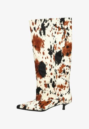 Stivali alti fino al ginocchio con stampa in pelle di mucca, caratterizzati da macchie marroni, nere e bianche. Punta appuntita e tacco basso e sottile. Superficie testurizzata.