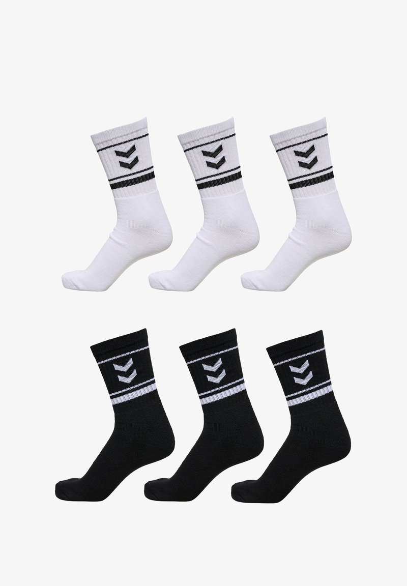 Drei Paar Sportsocken: zwei weiße mit schwarzen Zickzackmustern und zwei schwarze mit ähnlichen Designs, die gerippte Bündchen und eine strukturierte Oberfläche aufweisen.