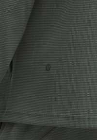 Tmavozelená mikina s textúrovanou tkaninou a malými opakujúcimi sa trojuholníkovými vzormi; obsahuje skrytú značku v strede.