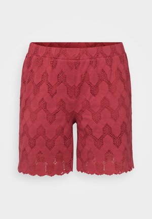 Sarkanas šorti, kas izgatavoti no mežģīnes ar zigzag rakstu, ar viļņotu maliņu un elastīgu jostasvietu ērtībai.