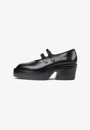 Czarne lakierowane buty na platformie z podwójnymi paskami z klamrami i grubym, rzeźbionym obcasem z wycięciem.