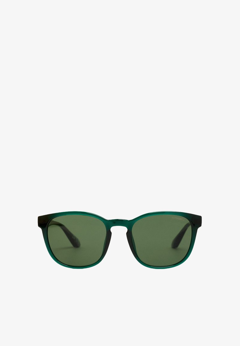 Gafas de sol con tinte verde, con un marco verde transparente y brazos oscuros. Lentes rectangulares y un diseño moderno y elegante.