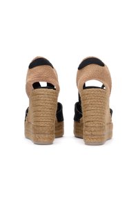 Espadrillas nere a zeppa con suola in juta, dotate di retro a taglio e accenti in tessuto testurizzato color beige sul tallone e sul ponte.