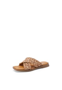 Infradito intrecciato in tonalità beige con cinturini incrociati. Suola piatta e punta aperta, caratterizzata da una superficie texturizzata e minimalismi nei dettagli hardware.