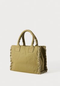 Olivengrønn stoff tote bag med frynser, doble robuste håndtak, firkantet form og en teksturert overflate.