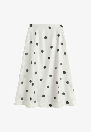 Jupe blanche en ligne A avec des pois noirs répartis uniformément sur le tissu, dotée d'une ceinture lisse et d'un ourlet mi-long.