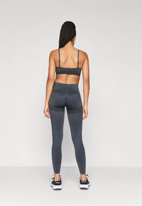 Σκούρο γκρι αθλητικό μπραζίλ και κολάν από ελαστικό ύφασμα, με λεπτές τιράντες και ψηλή μέση, υφή με ανάγλυφο φινίρισμα και χωρίς ορατά σχέδια.