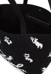 Czarna torba tote z kreskówkowymi psami w okularach przeciwsłonecznych, wewnętrzną kieszonką na zamek, materiałowymi uchwytami i zabawnym nadrukiem z białym napisem.